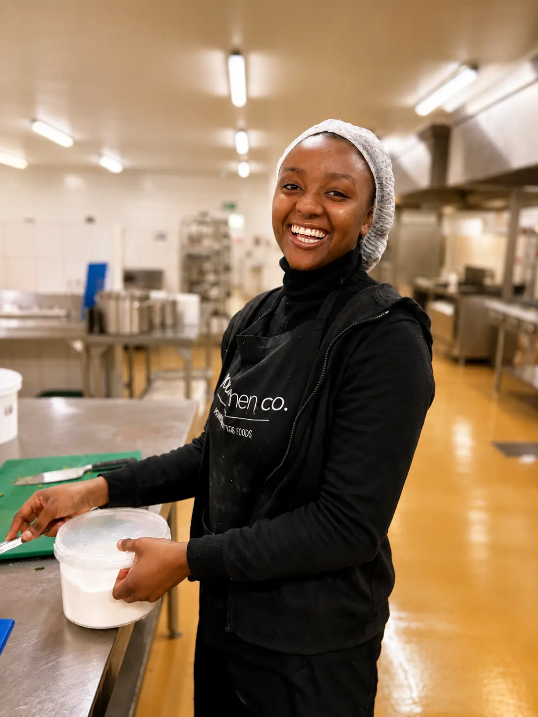 A smiling Your Kitchen Co team member in the kitchen